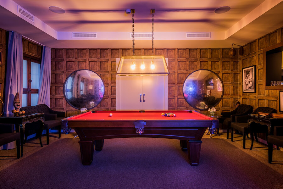 Billiards room at the Owner’s Club in Puente Romano, featuring a professional pool table, warm lighting, wood-panelled walls, and elegant décor in an exclusive and sophisticated setting.