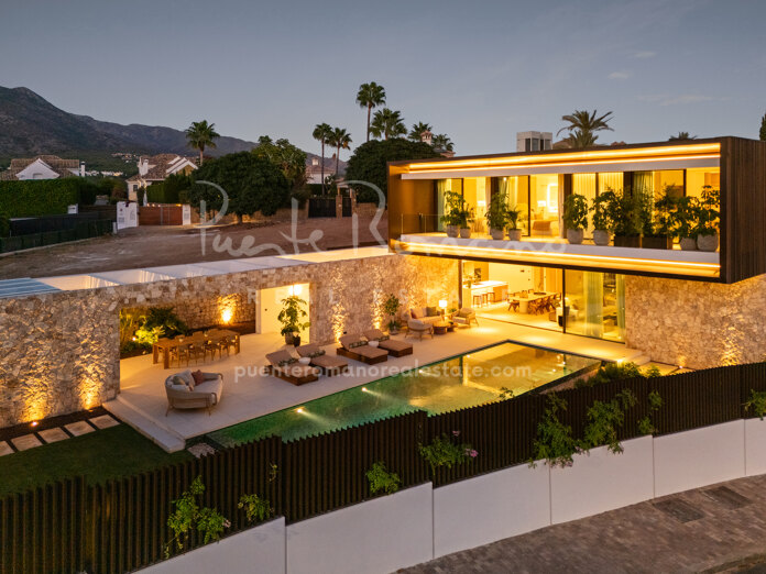 Villa contemporánea con diseño fluido entre interior y exterior, materiales naturales y lujosas áreas de bienestar